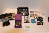 Full overview of the lot showing the wallet, multiple jewelry boxes, zippered pouch of jewelry, and cufflinks.