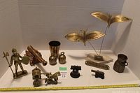 Full view of the collection of vintage brass items on display surface with white background.