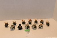 Full set of twelve ceramic anthropomorphic bug figurines arranged in a group, showing the overall lot contents and scale.