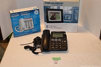 Photo showing all items including GE corded phone, black digital phone, and Panimage digital photo frame box
