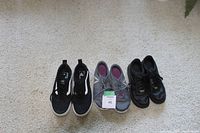 Three pairs of shoes displayed on carpet: Vans men's slip-ons, Reebok women's athletic shoes, Nike youth shoes.