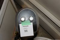 Close up top view of black vertical tower heater control panel showing two white knobs.