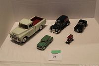 Overview of five toy vehicles including pickup truck, delivery van, compact car, sports car, and miniature fire truck.
