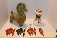 Photo shows the full lot with Trojan horse ceramic figurine, Aztec style vase, and four vintage clay fish ornaments on white backdrop.