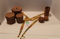 Full lot showing all woven baskets and beadwork strap arranged on white cloth background.