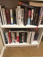 Full view of two shelves filled with assorted books, showing spines and some titles.