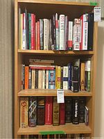 Bookshelves filled with multiple hardcovers and softcovers arranged vertically. A variety of titles including history, grammar, self-help, and fiction.