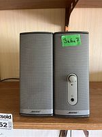 Front view of the pair of Bose Companion 2 Series II speakers, showing speaker grille, volume control knob, headphone jack, and brand logo.