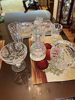View of nine pieces including vases, bowls, candy dishes and a decanter arranged on table with placemats