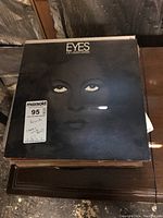 Stack of LP records with 'Eyes of Laura Mars' soundtrack album on top.