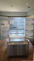 Frontal view of refrigerator with both fresh food doors open and freezer drawer closed.