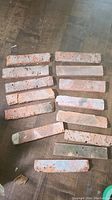 15 pieces of reclaimed red brick veneer laid out with visible cracks and wear