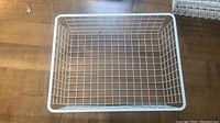Top-down view of one white wire basket showing grid pattern and rectangular shape