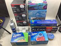 Full overview of the lot showing all items including boxed food storage bags, soap bars, hand lotion, masks, and wraps.