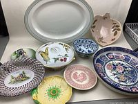 Wide shot of assorted vintage china plates and bowls showing various shapes and decorative patterns