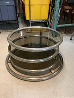 Front view of coffee table collapsed showing round smoked glass top and chrome circular base