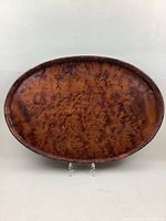 Full view of the oval tray showing the entire surface and carved edge.
