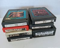Ten assorted classic rock 8-track tapes stacked in piles, showing multiple artist labels including Earth Wind & Fire and others.