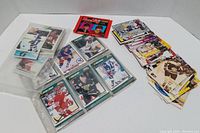 Hockey cards displayed in plastic sleeves on left side and multiple stacks of loose cards on right side.