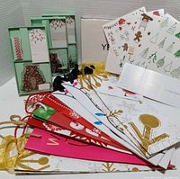 Photo shows two temporary tattoo gift packs with festive Christmas-themed designs, multiple colorful Christmas wine bags, and three teddy bear shaped gift tags.