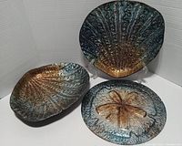 Front view of the three decorative ceramic pieces showing detailed textures and blue to gold gradient glazes.