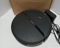 Top view of the Roborock E4 robot vacuum with its charging station and packaging.
