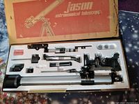 View of the telescope and various accessories including eyepieces, mounts, and mechanical components inside the original box styrofoam.