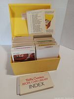 Open view showing yellow recipe card box with neatly organized Betty Crocker recipe cards and index booklet in front.