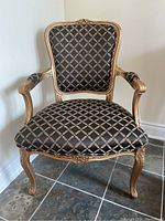 Front view of armchair showing carved crest, upholstery and overall form