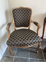 Front view of chair showing diamond-patterned upholstery and carved crest