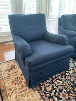 Blue upholstered armchair from front left angle showing overall shape and fabric pattern.