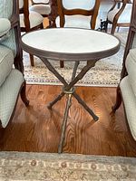 Front view of table showing round marble top and twig-style base