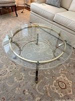 Top-down view of entire table showing round brass frame and glass top