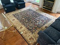 Overhead view of navy central field and beige border with floral motifs