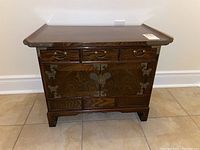 Front view showing three top drawers, two central doors with butterfly lock hardware, and three lower hidden drawers