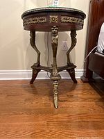 Front view of the table displaying the inlaid top under glass and gilt brass legs