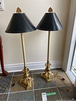Front view of both lamps showing full height, brass bases with fish motif and black shades