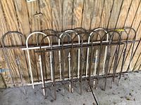 Five fence sections leaning against wooden siding, full lot view