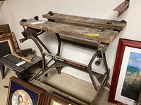 Side and angled view of Black & Decker WorkMate workbench showing wooden top, metal frame, and adjustment handles.