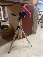 Full view of the Laserman Tracer laser level mounted on the adjustable tripod standing on a basement floor.