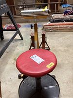 Photo of the adjustable rolling stool and two jack stands in a basement workshop environment.
