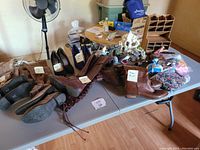 Table with six pairs of shoes and boots, plus aquarium decoration items including coral-like ornaments and plastic plants.