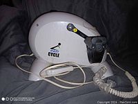 White Easy Cycle pedal exerciser with foot pedals, straps, power cord, and handheld remote control, shown from side and top angles.