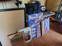 Image of framed wall art and framed mirror pieces lined against a wall, showing varied home decor items.