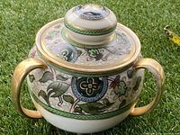 Side view showing the cookie jar body with two handles and detailed Nippon style floral and gold accents.