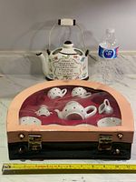 Photo showing the pink and black kids tea set case with ceramic set inside, water bottle for size reference.