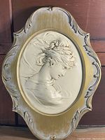 Full view of vintage cameo wall plaque mounted on carved wooden frame.