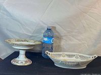 Pedestal fruit bowl and oval fruit bowl shown beside a water bottle for size reference