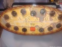 Front view of the 24 Canadian provincial quarters mounted on an oval display with a vintage Canada map background, labeled 1999 Millennium.