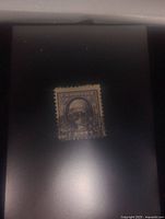 Stamp centered on black background showing front with George Washington portrait, purple color, and cancellation marks.